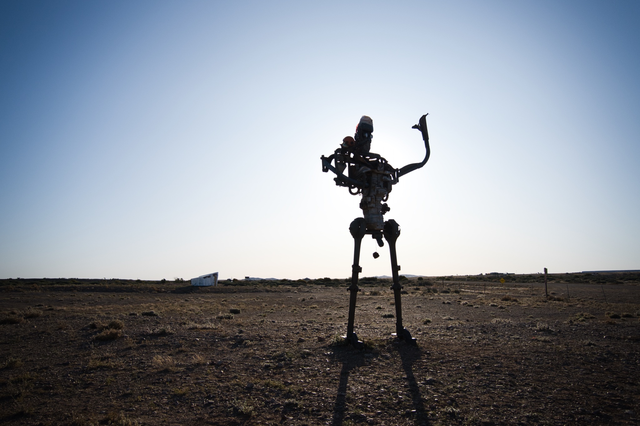 Tall robotic man sculpture in the sunset