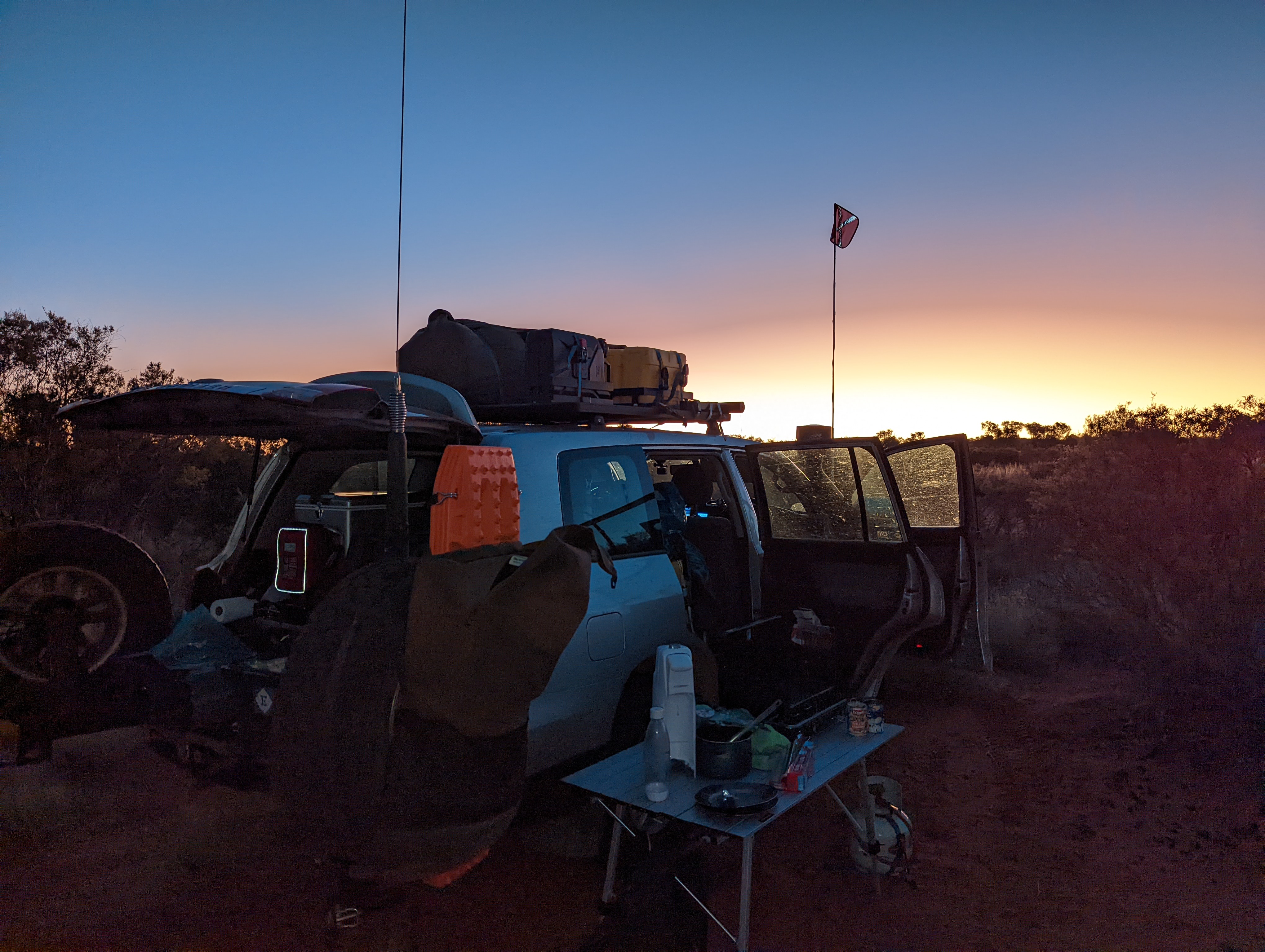 Our car and camp equipment in front of a sunset