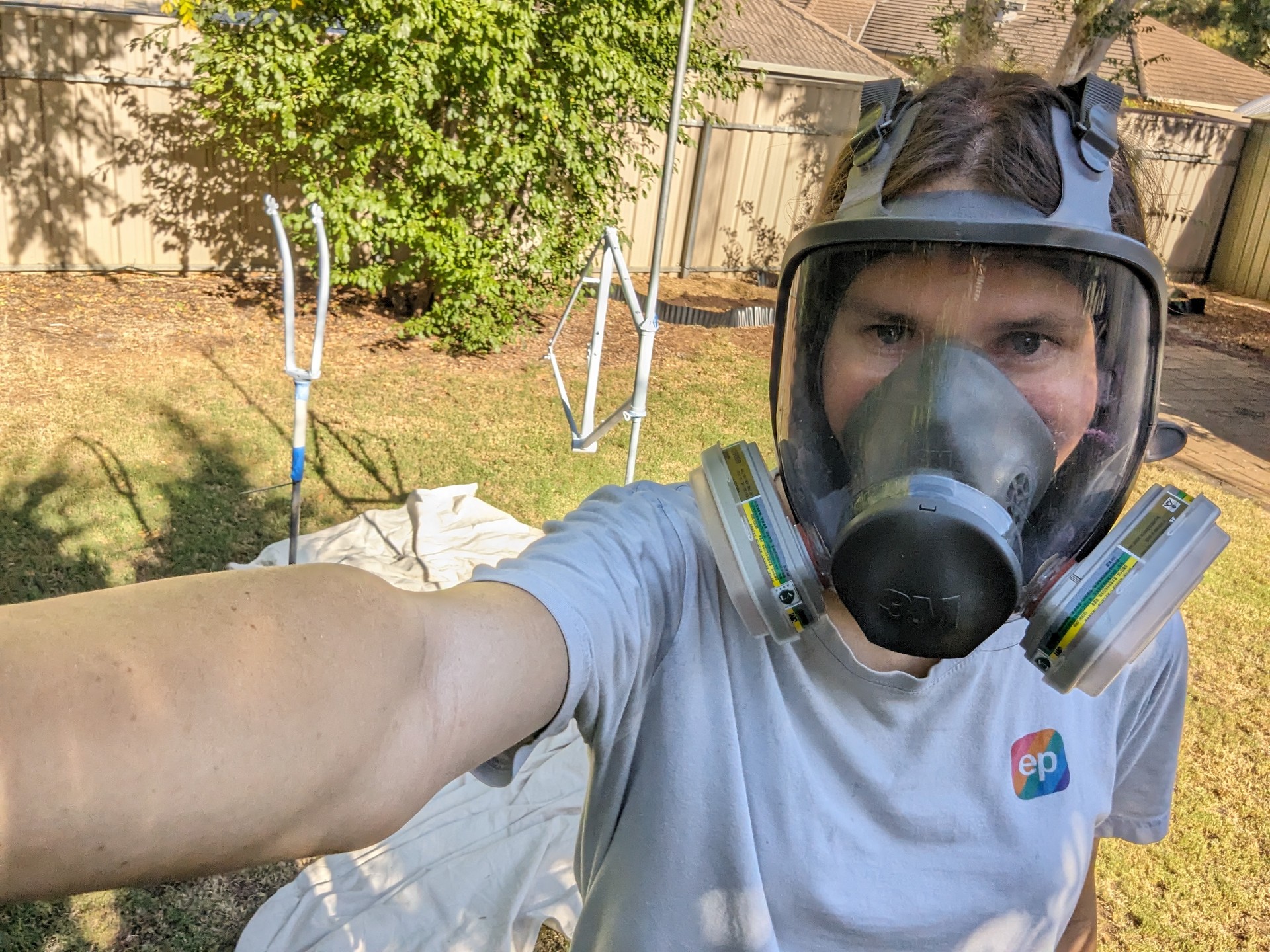 Selfie of me in full face respirator with bike in background